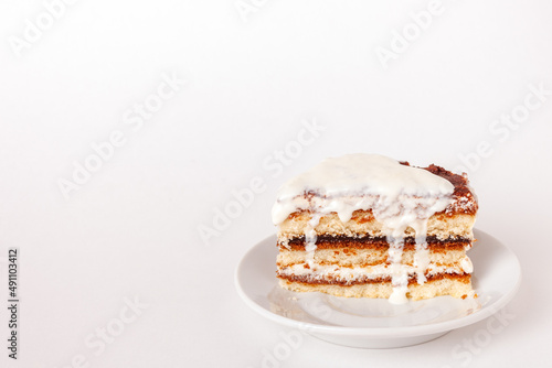 one piece of tiramisu with dripping cream on white background with copy space
