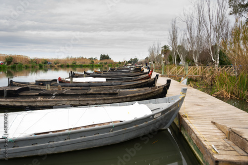 puerto de catarroja  vista de barcos y barcas de madera t  picos de pesca de la albufera de valencia amarrados a los muelles de madera .