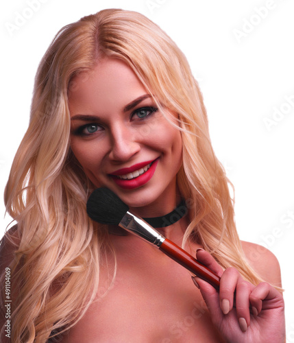 Beauty portrait of woman with makeup brush near face