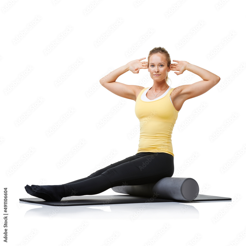 Portrait of health and fitness. A young woman sitting on a foam roller and turning left and right to strengthen her core. Portrait of health and fitness. A young woman sitting on a foam roller and turning left and right to strengthen her core.