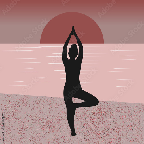 silhouette of female in yoga pose on the beach at sunset