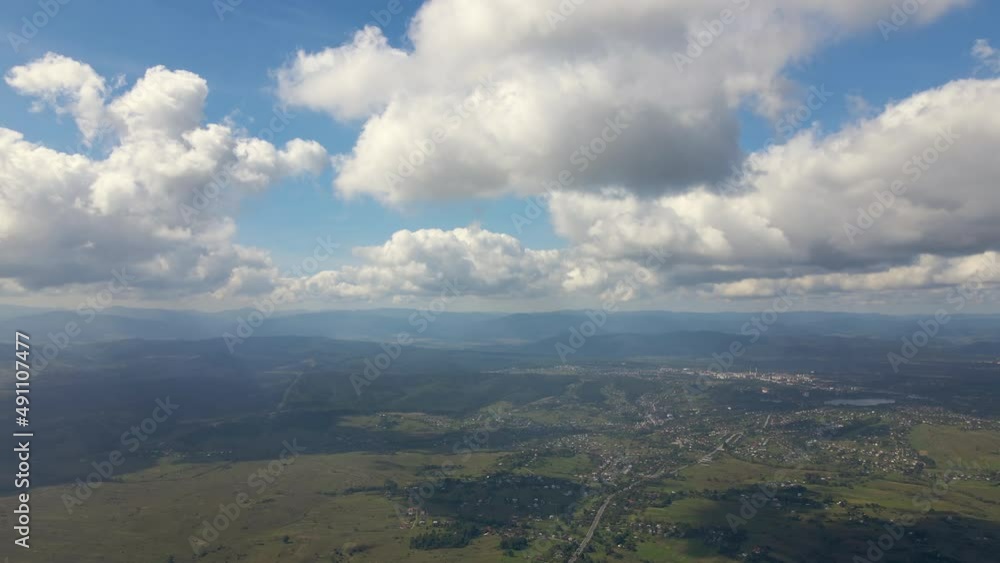 Aerial view from airplane window at high altitude of earth covered with white puffy cumulus clouds Aerial view from airplane window at high altitude of earth covered with white puffy cumulus clouds