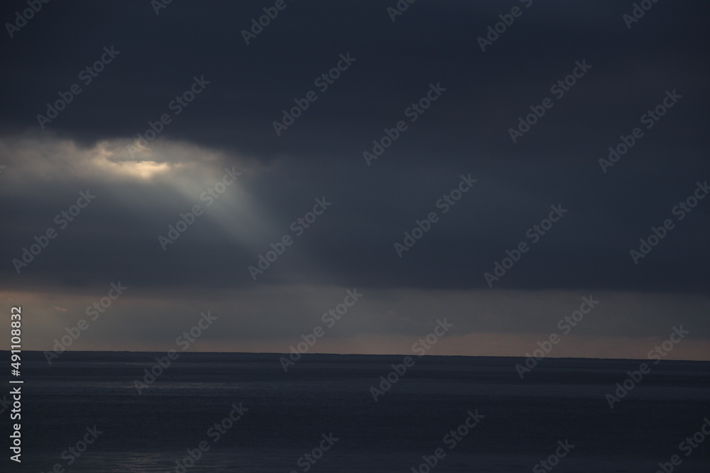 Ray light between the clouds over the ocean