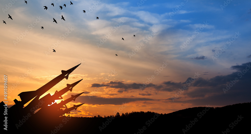 The missiles are aimed at the sky at sunset. Nuclear bomb, chemical weapons, missile defense, a system of salvo fire. - obrazy, fototapety, plakaty 