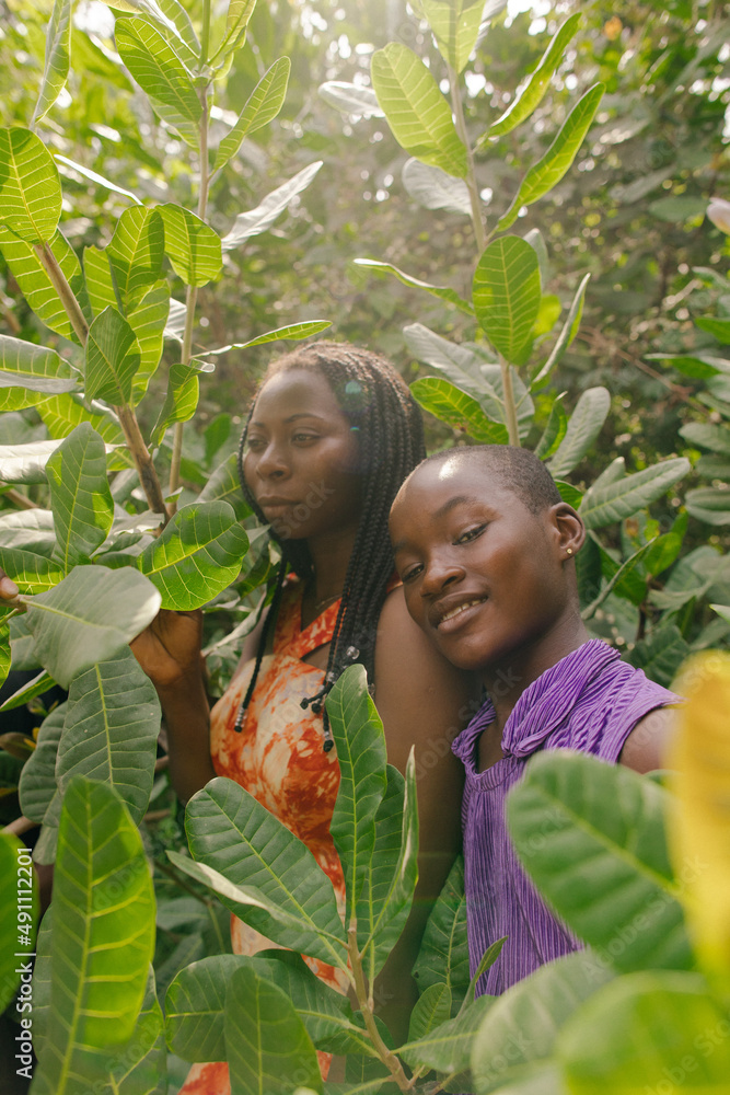Portrait of a black african mother and daughter nature activists standing within nature under the sunlight Portrait of a black african mother and daughter nature activists standing within nature under the sunlight