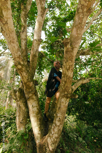 Portrait of young male black african nature activist climbing a tree
