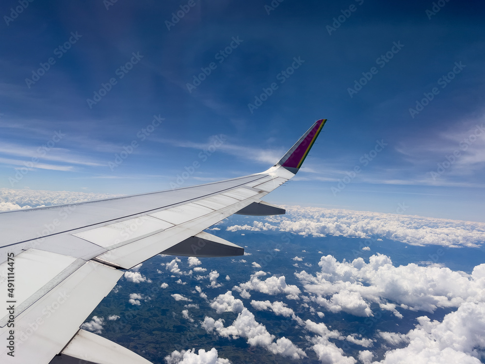 Aerial view through airplane window of Rio de Janeiro city, Brazil. Exuberant view of one of the most beautiful places in the world. Sunny day with some clouds