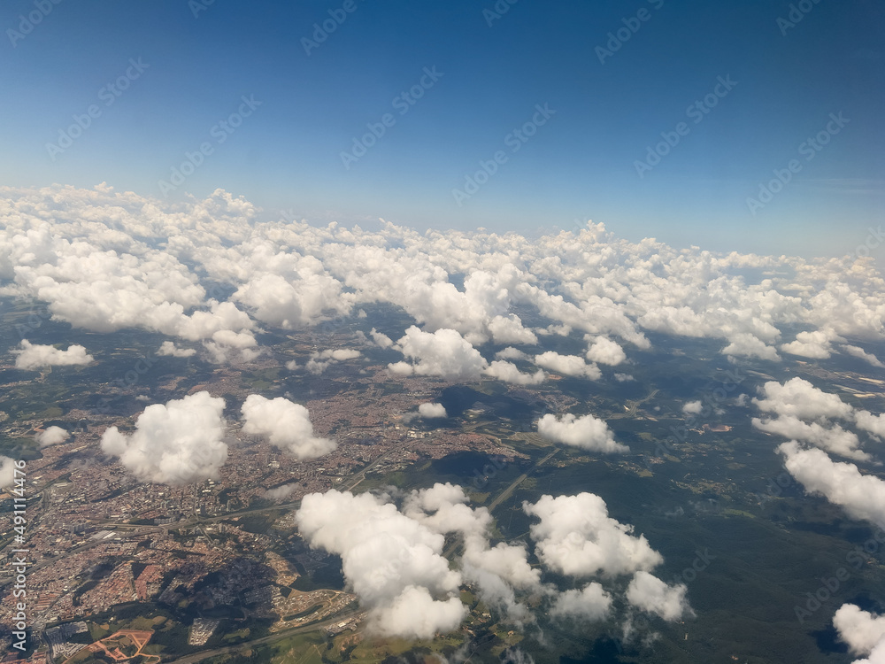 Aerial view through airplane window of Rio de Janeiro city, Brazil. Exuberant view of one of the most beautiful places in the world. Sunny day with some clouds