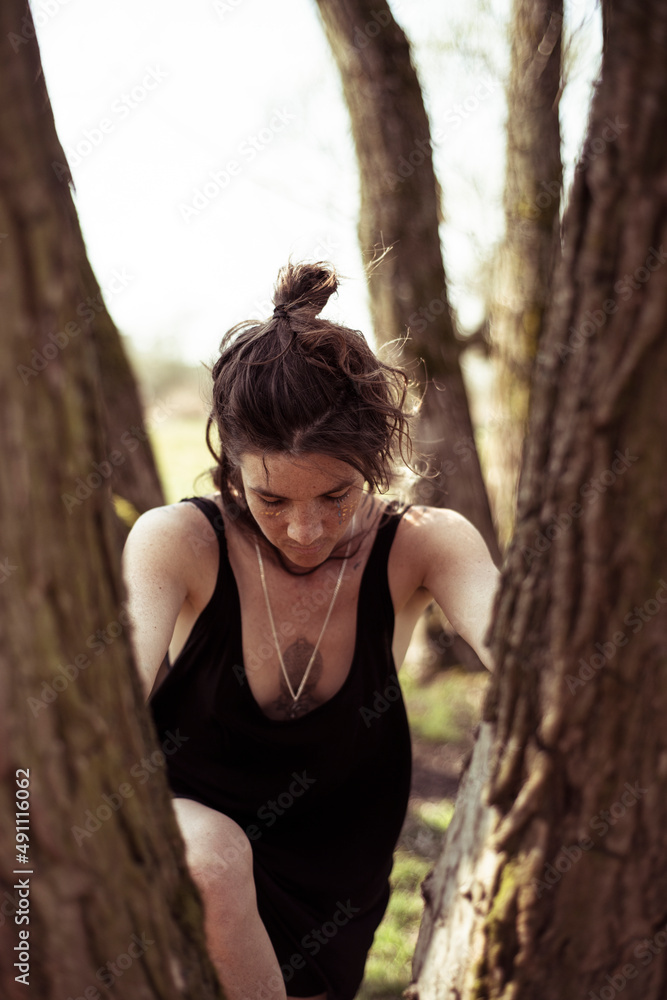 natural woman with face paint and freckles climbs tree in german natur natural woman with face paint and freckles climbs tree in german natur