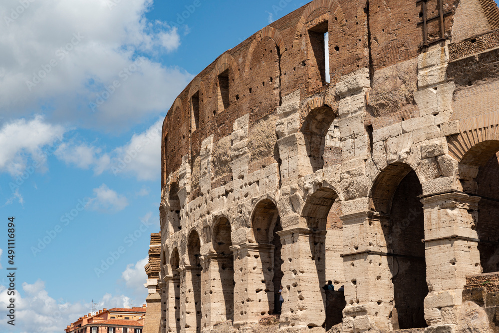 detail of the colosseum on a sunny day with clouds