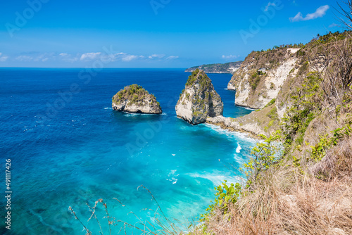 Amazing tropical view of a secret beach with cliffs and blue ocean in Nusa Penida, Indonesia.