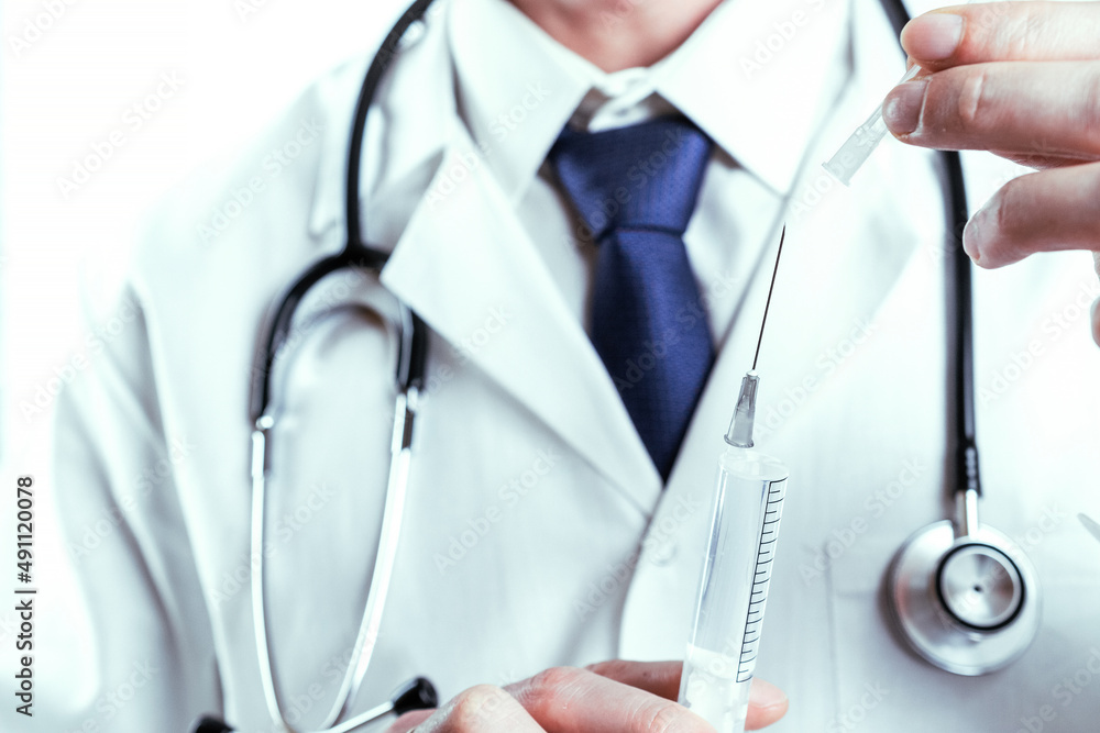 Needle doctor medical injection. Nurse hand in blue gloves holding syringe with needle. Selective focus, hospital white doctor gown, stethoscope. Medication drug needle syringe drug, medical vaccine. Needle doctor medical injection. Nurse hand in blue gloves holding syringe with needle. Selective focus, hospital white doctor gown, stethoscope. Medication drug needle syringe drug, medical vaccine.