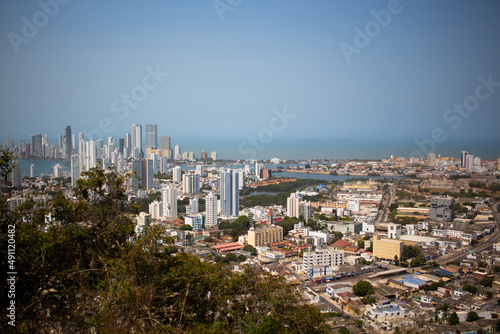 A beautiful photo of a seaside city from above, skyscrapers, hotels and residential buildings, bright sun, heat, Cartagena Colombia