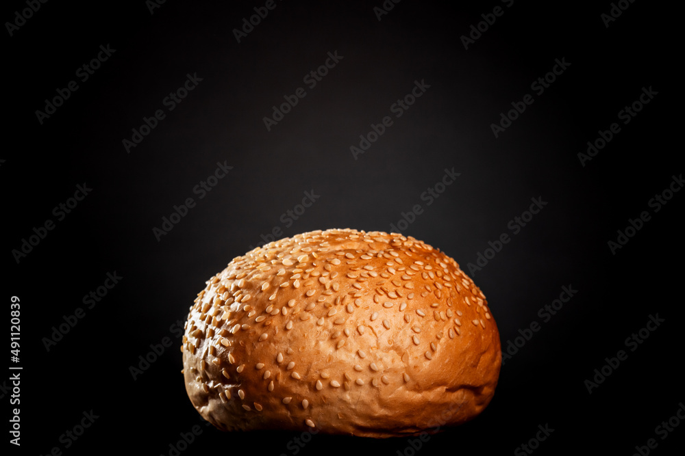 burger bun with sesame seeds on black background.. burger bun with sesame seeds on black background..