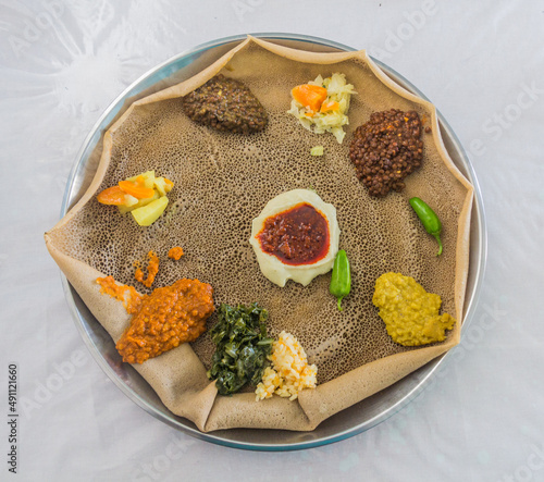 Typical meal in Ethiopia - Beyainatu. Meaing bit of everything. Mix of vegetables and stews on injera flatbread. photo