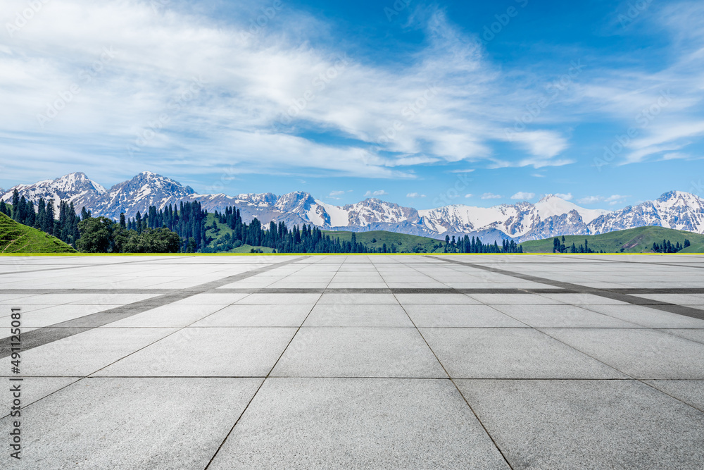 Empty square floor and snow mountain under blue sky. Road and mountain background.