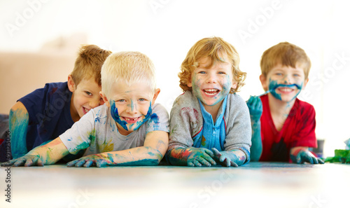 Kids will be kids. Portrait of four cute little boys covered in paint. photo