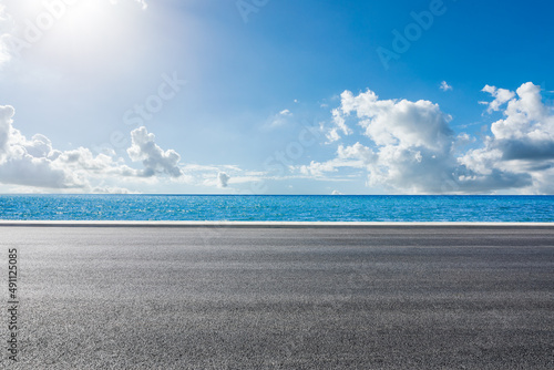 Fototapeta Naklejka Na Ścianę i Meble -  Empty asphalt road near the lake under blue sky