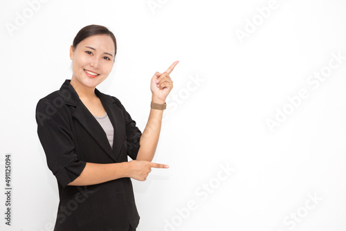 Beautiful Asian business woman wearing black suit presenting something on white background and copy space. Confident Asian working woman smiling and cheerful