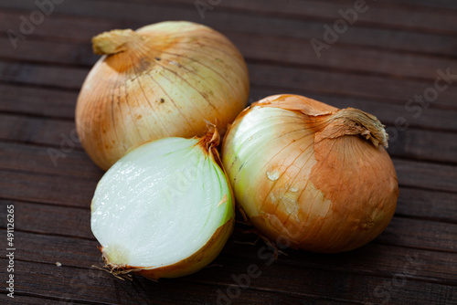 Agricultural production, fresh raw bulbs onion on wooden table