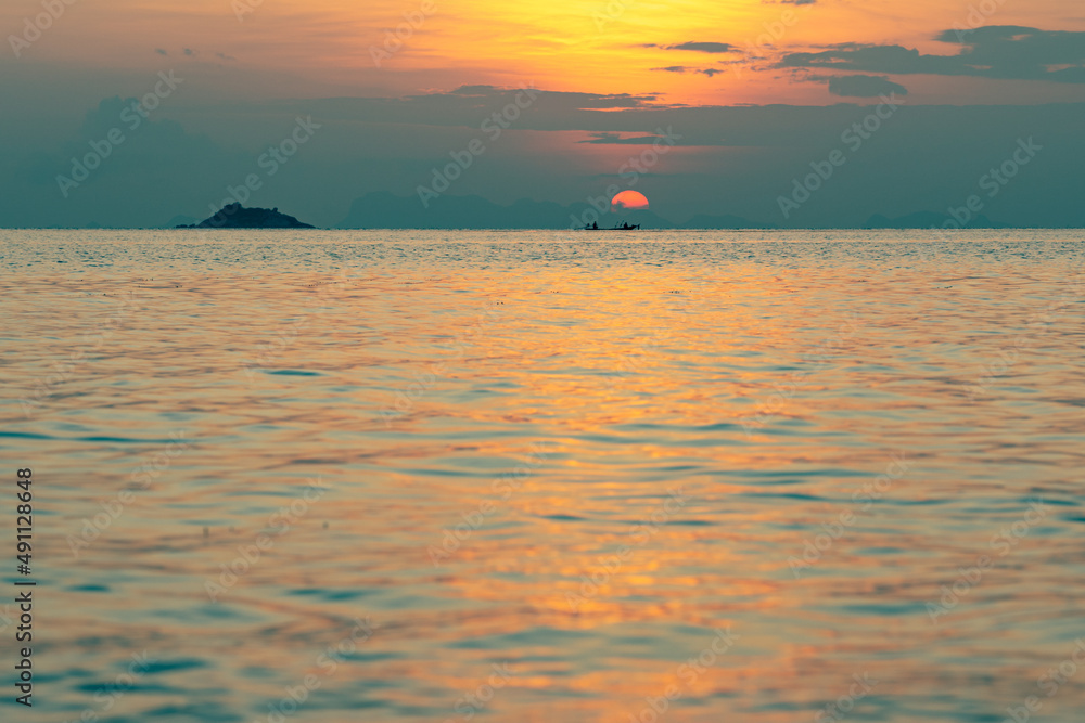 Colorful sky over sea and islands. Sun setting in the sea. Fisherman boat on the horizon.