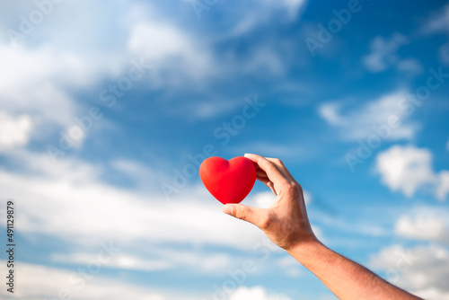 hand holding beautiful heart up to the sky.