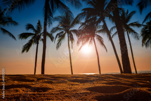 close up sand beach with coconut trees background at sunset