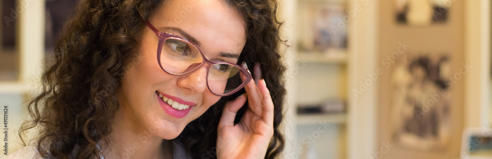 Young beautiful woman choosing eyeglasses in optical shop. Young beautiful woman choosing eyeglasses in optical shop.