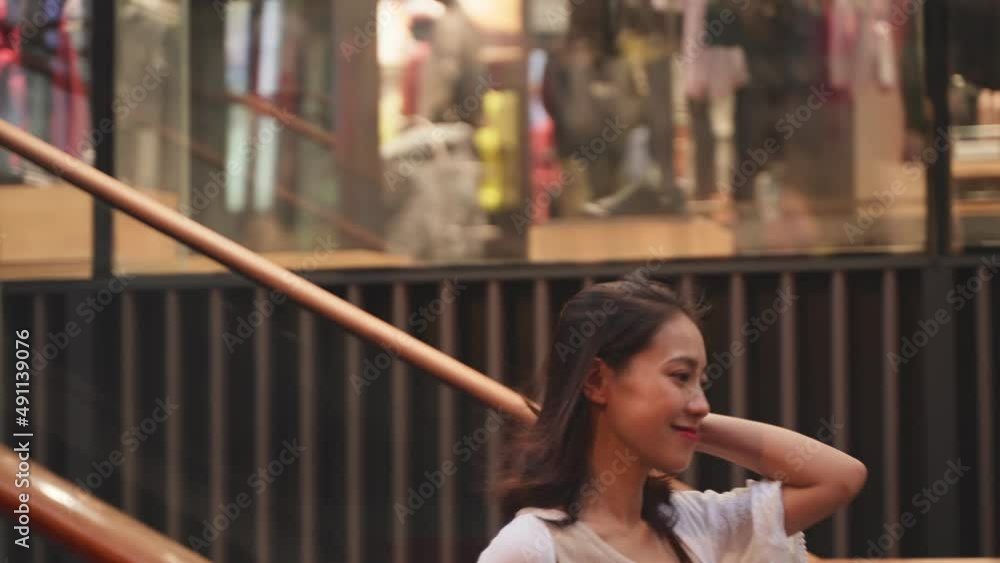 Young Charming Sexy Chinese Woman in White Shirt Waking down Steps Quickly and Happily with a Big Smile, Touching Nice Brown hair with One Hand Young Charming Sexy Chinese Woman in White Shirt Waking down Steps Quickly and Happily with a Big Smile, Touching Nice Brown hair with One Hand