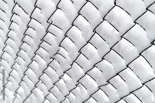 Rabitz mesh covered with snow. Background texture.