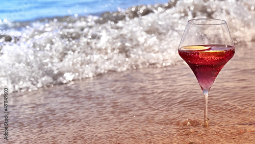 Wine glass with a cocktail by the sea.