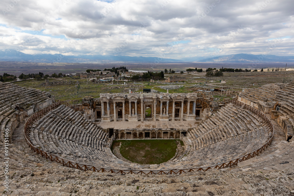 Amphitheater in ancient city of the Hierapolis. Dramatic sunset sky. Unesco Cultural Heritage Monument. Pamukkale, Turkey