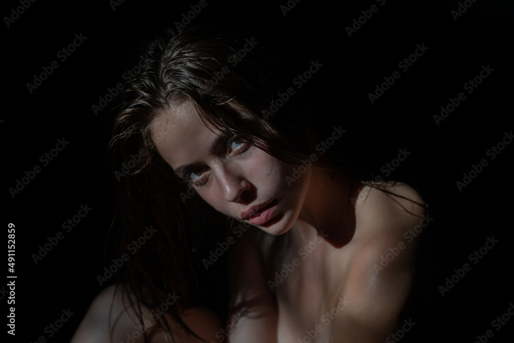 Portrait of elegant woman with light on a black background. Beautiful female face in the darkness. Tender girl, tenderness. Portrait of elegant woman with light on a black background. Beautiful female face in the darkness. Tender girl, tenderness.