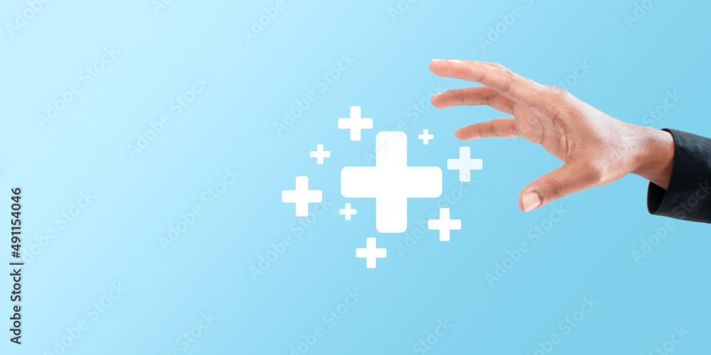 Obraz premium Male hand holding plus icon on blue background. Plus sign virtual means to offer positive thing (like benefits, personal development, social network)Profit,health insurance, growth concepts.