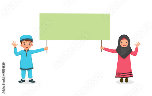 cute little muslim kids boy and girl waving hands while holding blank billboard sign for copyspace advertising and announcement messages