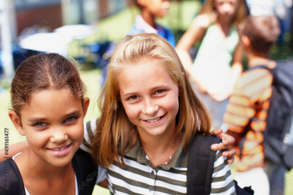 We love hanging out at school together. Two schoolgirl friends standing next to each other smiling up at the camera - copyspace. We love hanging out at school together. Two schoolgirl friends standing next to each other smiling up at the camera - copyspace.