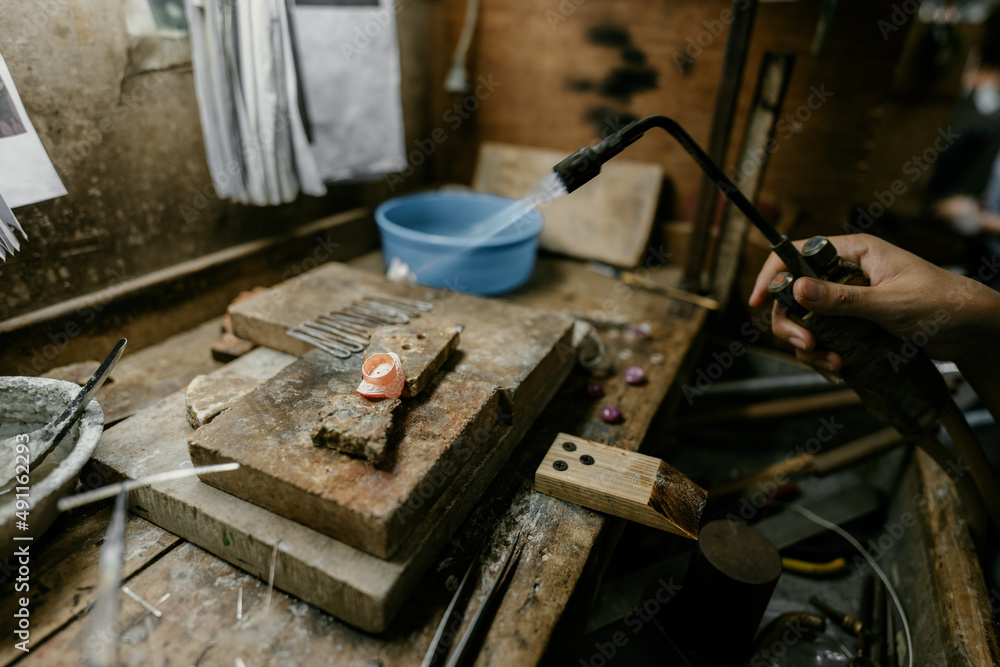 Jeweler at work in jewelry. Desktop for craft jewelry making with professional tools. Close up view of tools. Silver jewelry. Jeweler at work in jewelry. Desktop for craft jewelry making with professional tools. Close up view of tools. Silver jewelry.
