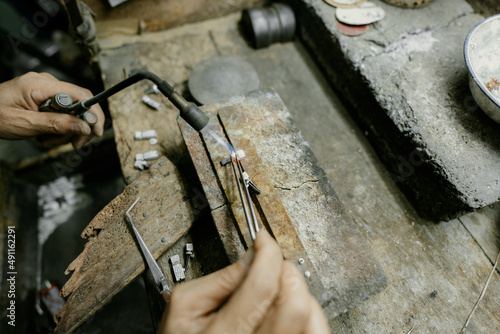 Jeweler at work in jewelry. Desktop for craft jewelry making with professional tools. Close up view of tools. Silver jewelry. 