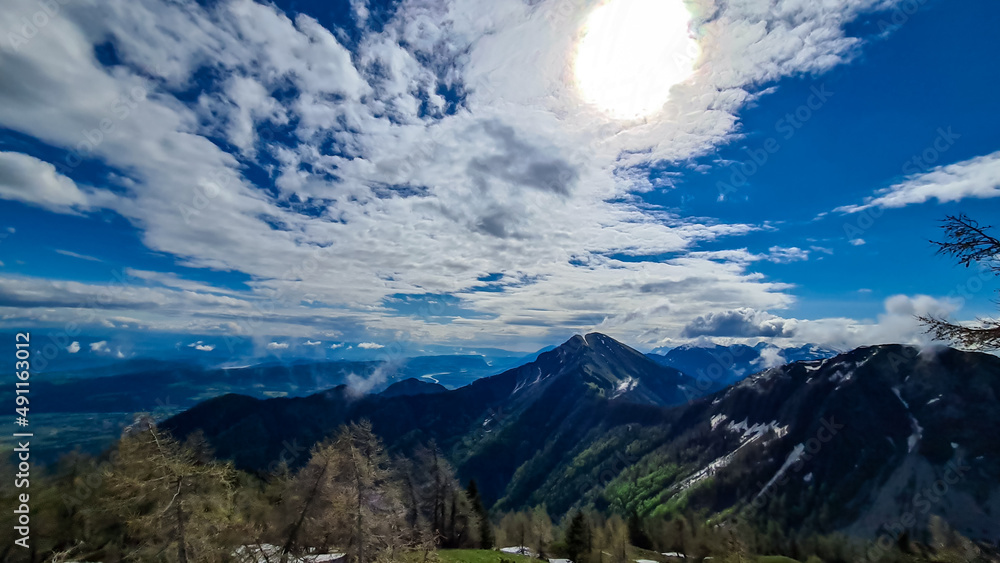 Fototapeta premium Panoramic view near Frauenkogel on the mountain peaks in the Karawanks, Carinthia, Austria. Borders Austria, Slovenia, Italy. Triglav National Park. Looking on mount Kahlkogel (Golica). Forest valley