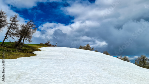 Snow covered hiking trail leading to the summit of Frauenkogel (Dovska Baba) in the Karawanks, Carinthia, Austria. Borders with Slovenia. Triglav National Park. Cross on the peak. Clouds builing up photo