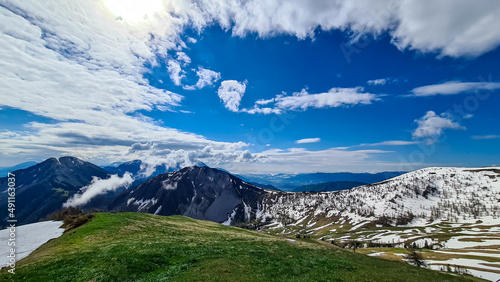 Panoramic view in spring near Frauenkogel on mountain peaks in the Karawanks, Carinthia, Austria. Borders Austria, Slovenia, Italy. Triglav National Park. Alpine meadows. Alm. Snow fields melting photo