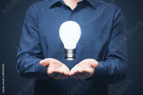 Close up of man hand holding glowing light bulb. Idea and innovation concept. photo