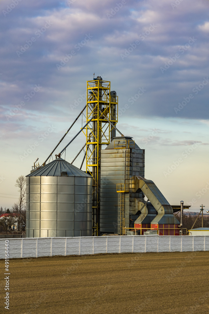 Obraz premium agro silos granary elevator. Silos on agro-processing manufacturing plant for processing drying cleaning and storage of agricultural products, flour, cereals and grain.