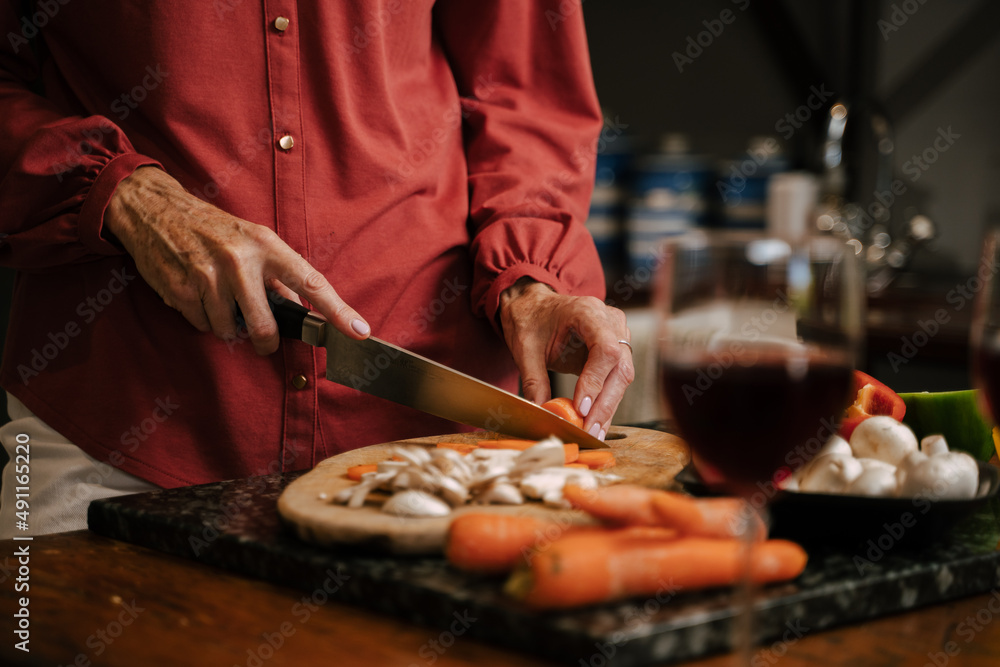 Caucasian senior female chopping vegetables in kitchen