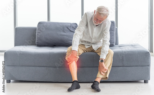 Obraz na płótnie Health care and problem concept Uhappy senior man suffering from knee ache at home