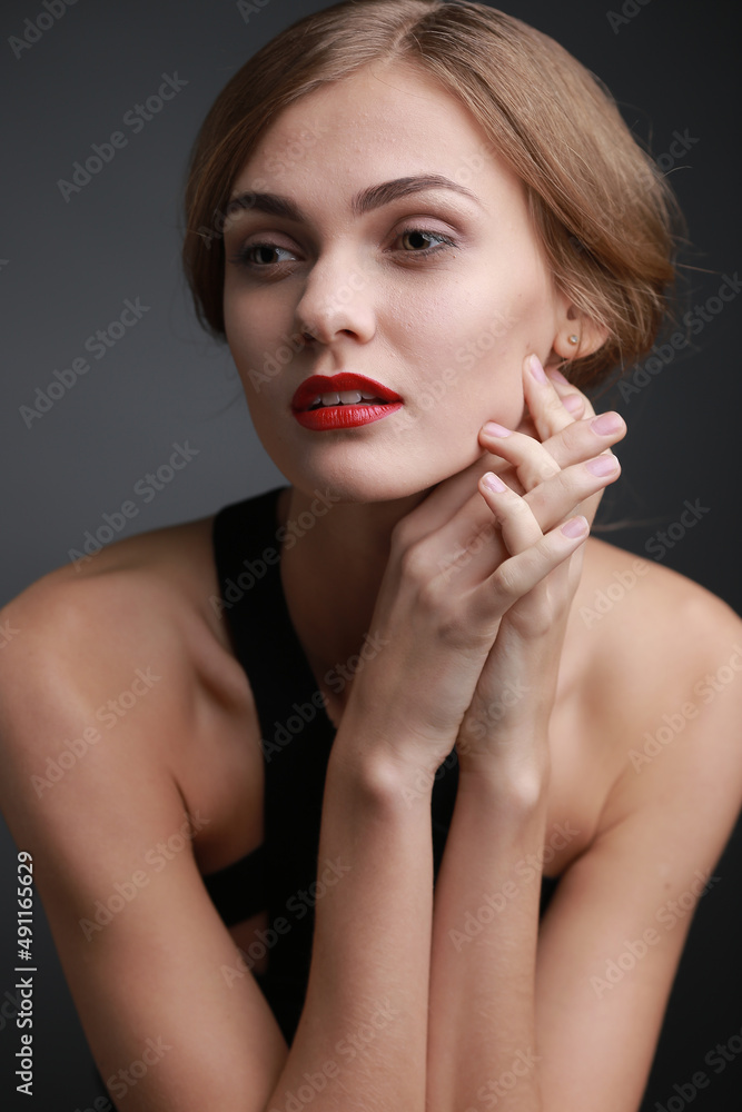 Fototapeta premium expressive studio portrait of a young attractive girl in a black dress