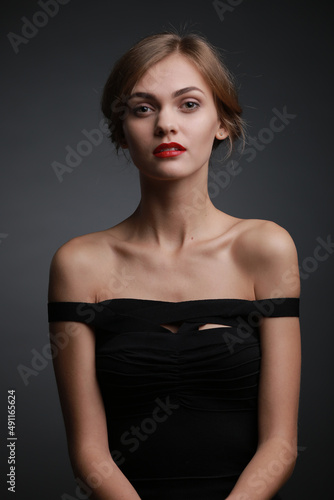 expressive studio portrait of a young attractive girl in a black dress