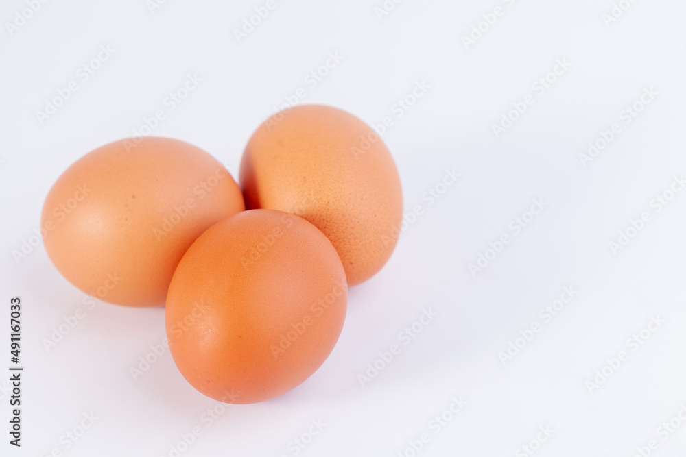 Three eggs are placed on a white background with free space on right Three eggs are placed on a white background with free space on right