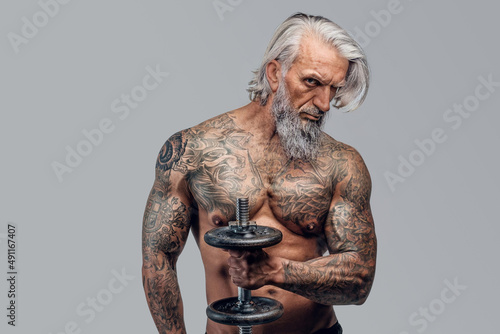 Brutal old man bodybuilder with dumbell isolated on white