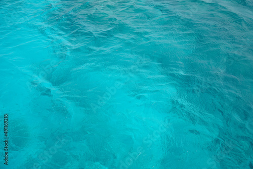 Abstract natural background, surface, texture. Waves of blue sea water. Copy space. Selective focus.